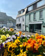 Colourful flowers in front of the green building that is the Seahorse coffee shop.